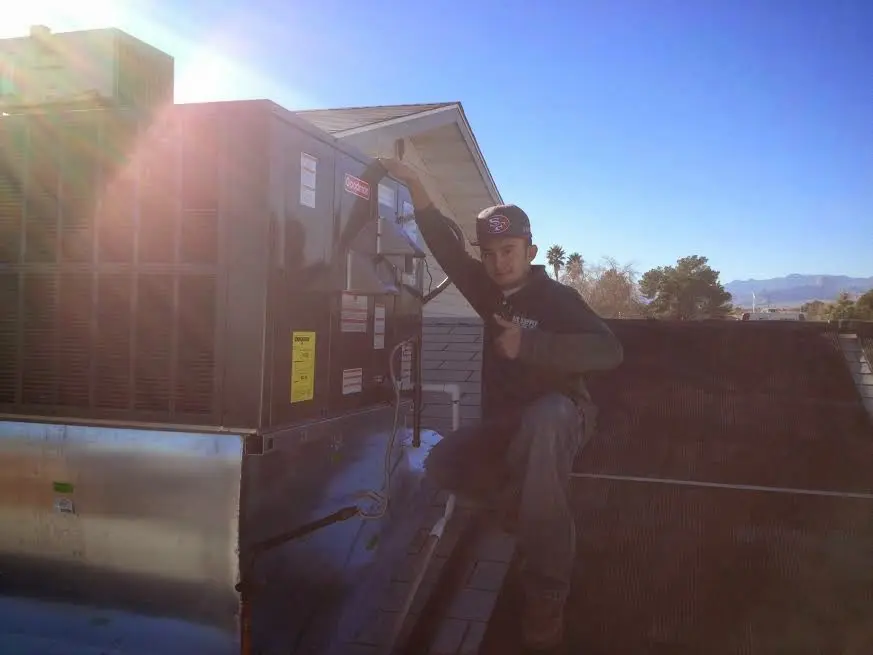 HVAC technician performing AC Tune-Up on a rooftop unit in Eidson Road